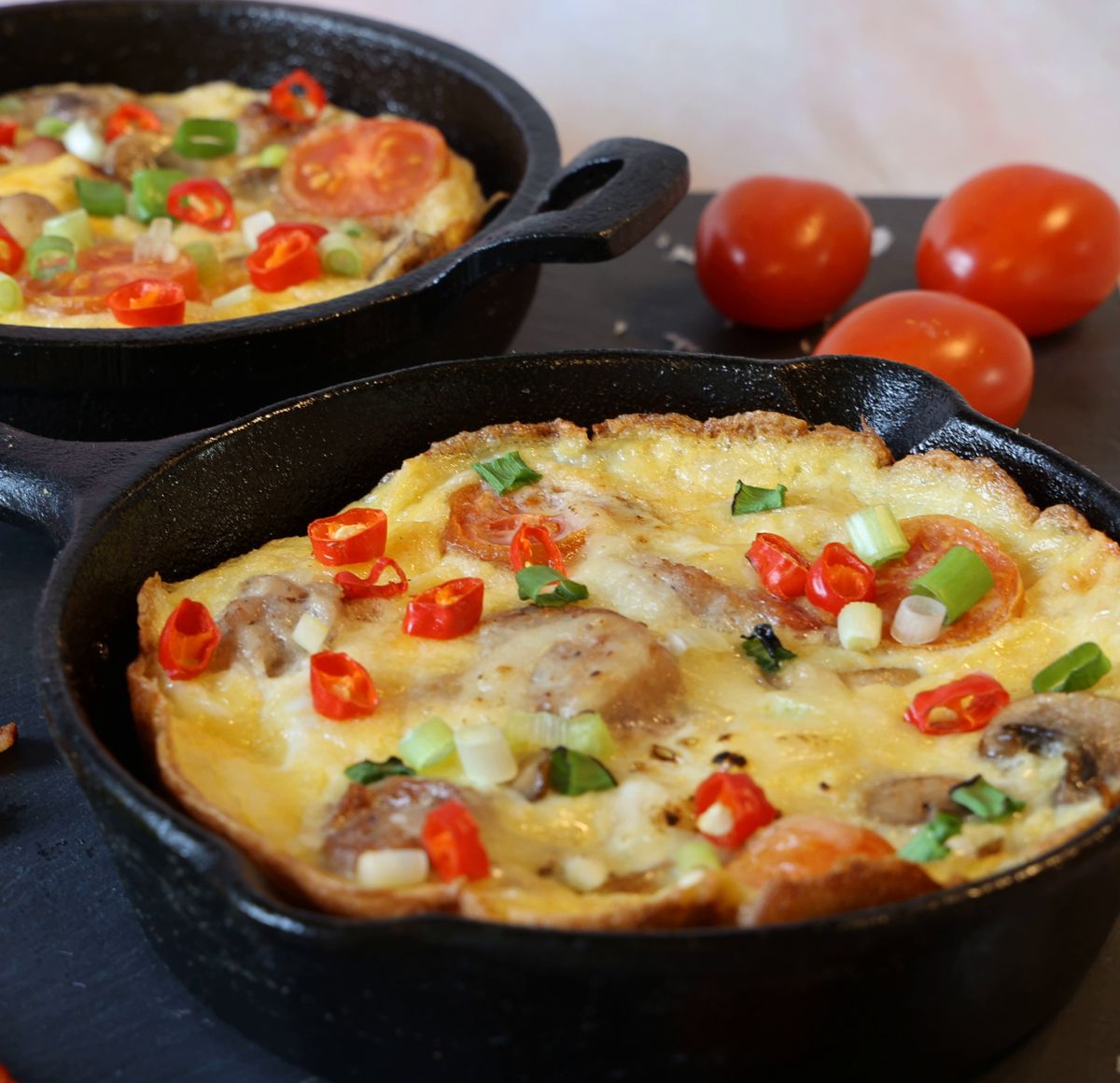 Zöldséges frittata öntöttvas serpenyőben gombával és koktélparadicsommal