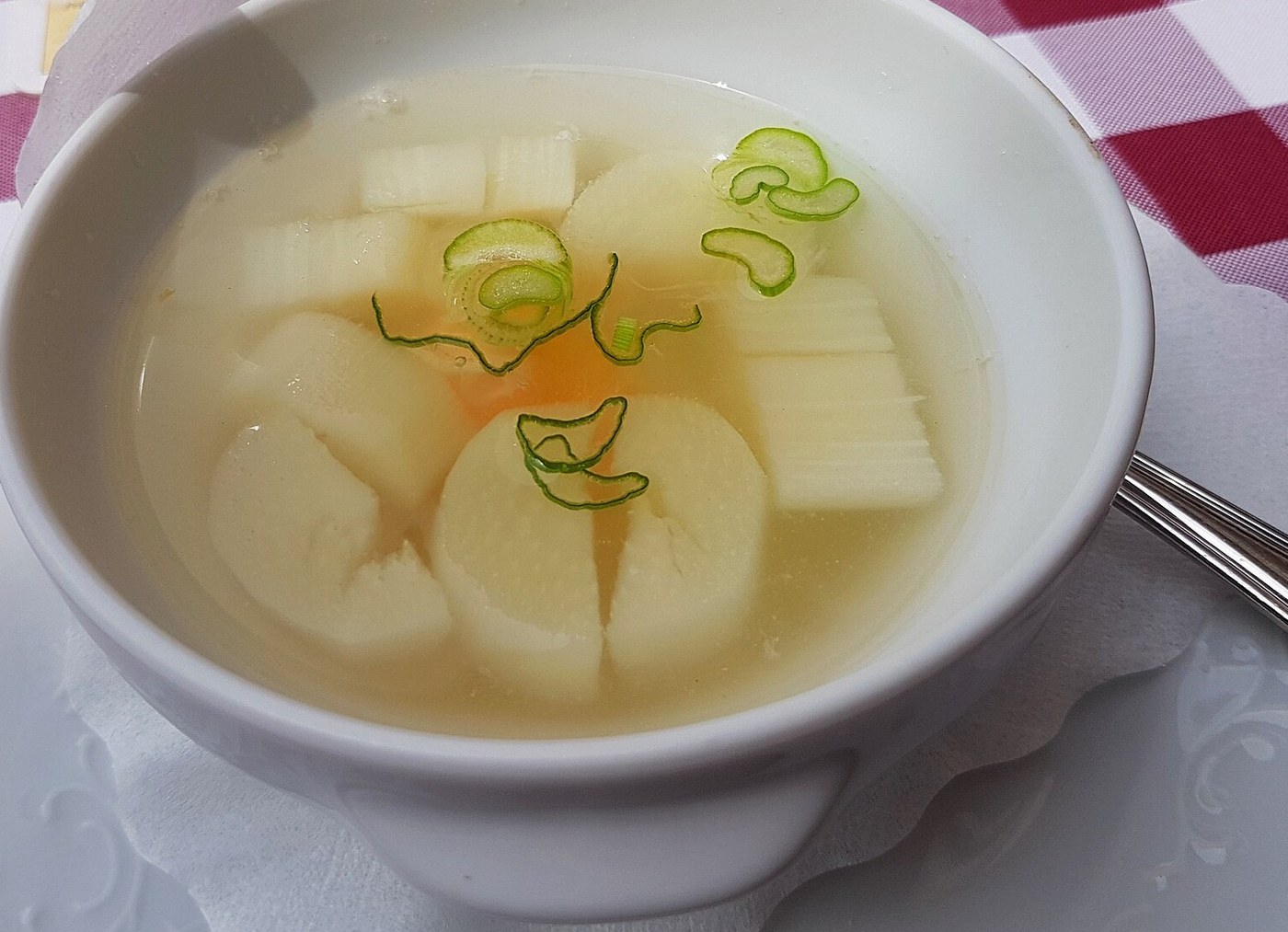 Fehér spárgadarabok light lében, lágy tojással és snidlingszálakkal, fehér tálban