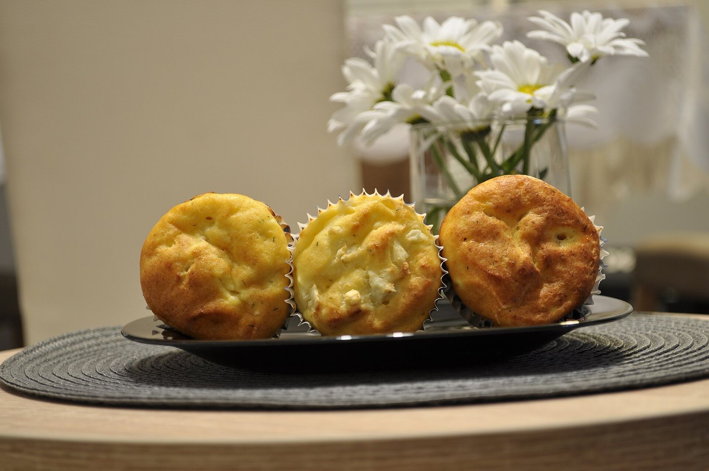 Sós túrós-sajtos muffinok papírkapszliban, aranybarna tetővel, tányéron